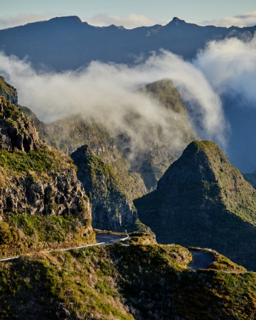 Clouds crest over a distant mountain ridge.     Size: 4480 x 5600